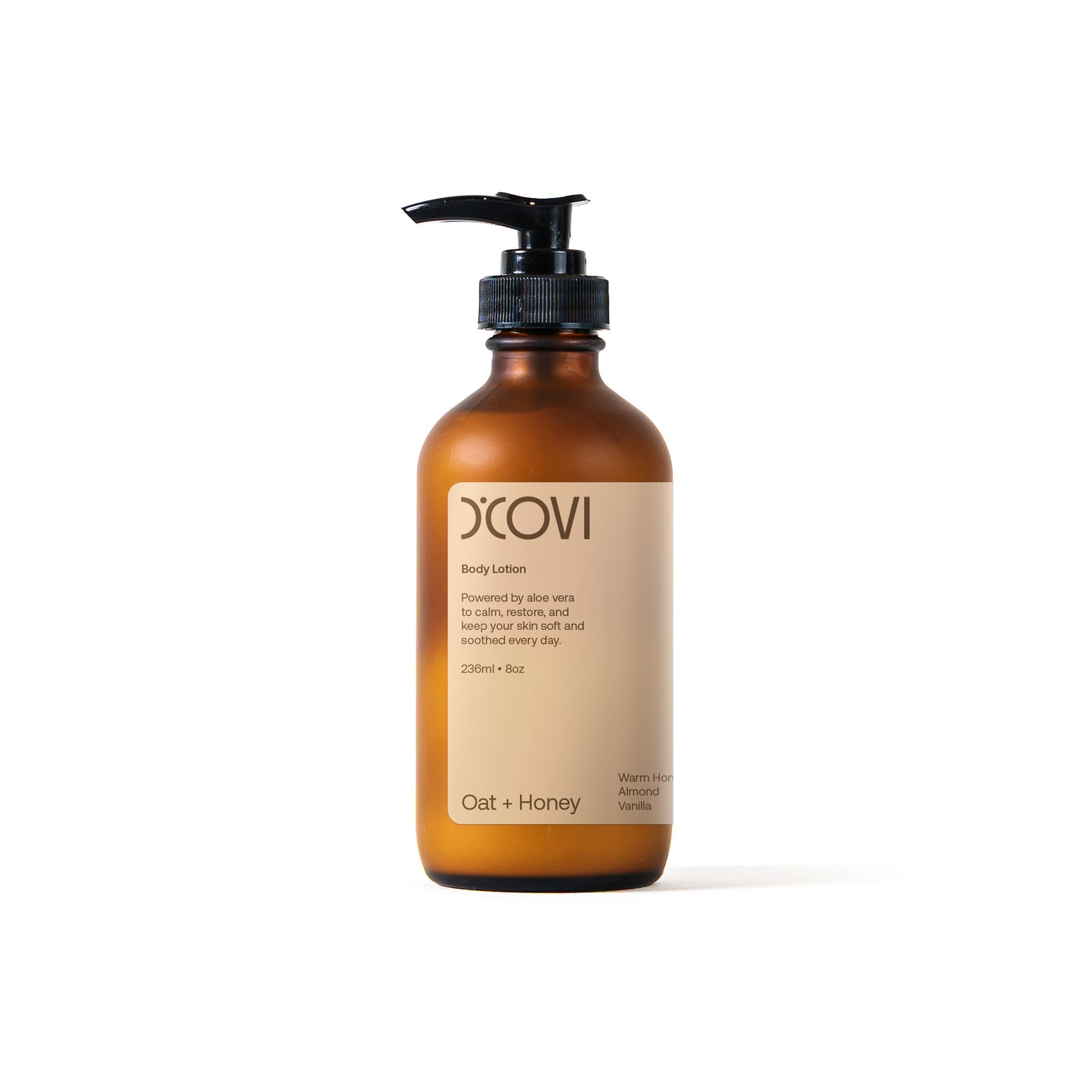 D’Covi body lotion glass bottle with black pump dispenser and tan label containing 236ml (8oz) of body lotion scent, “Oat + Honey”.