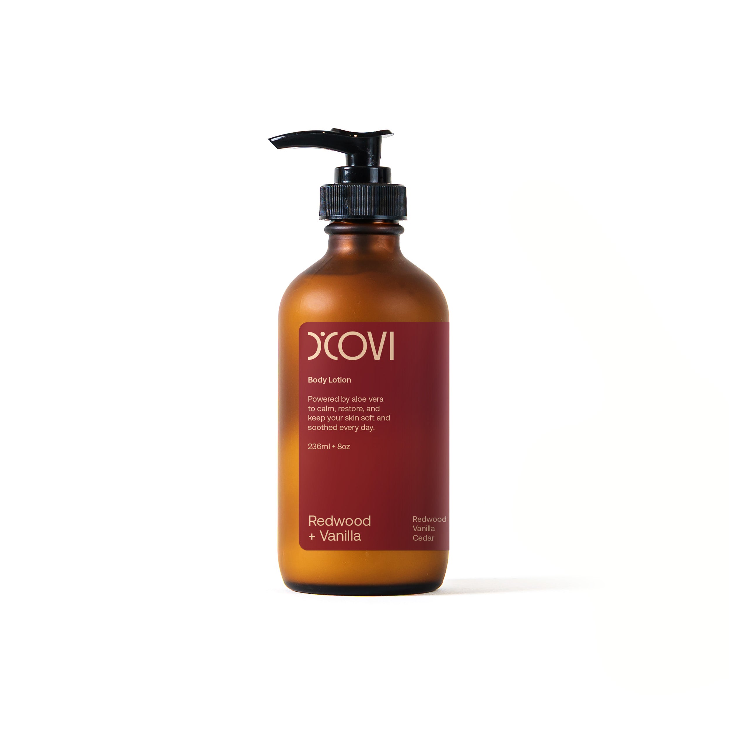 D’Covi body lotion glass bottle with black pump dispenser and burgundy label containing 236ml (8oz) of body lotion scent, “Redwood + Vanilla”.